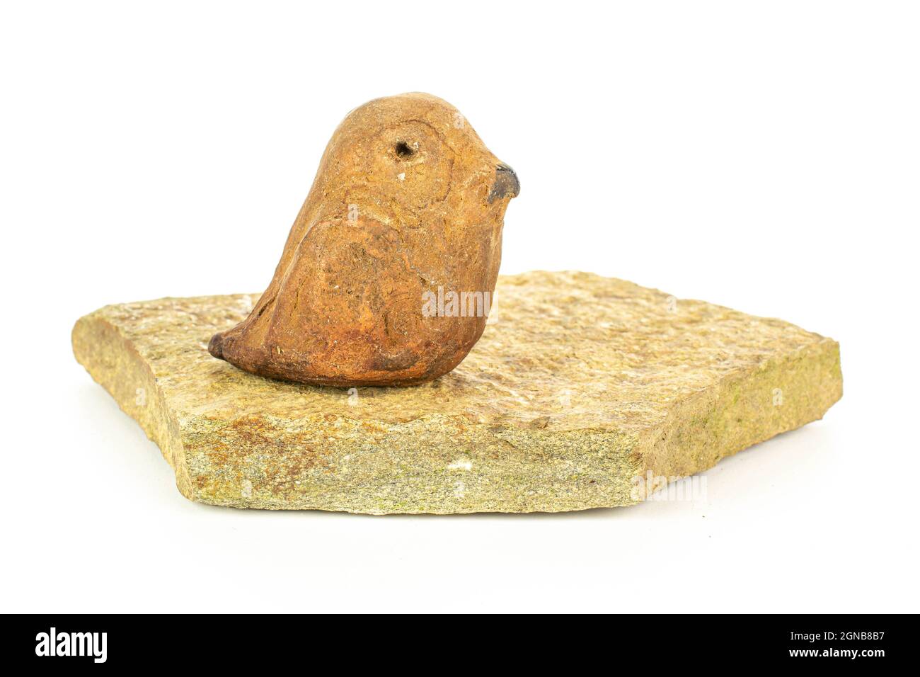 Ceramic bird on flat rock isolated on white background Stock Photo
