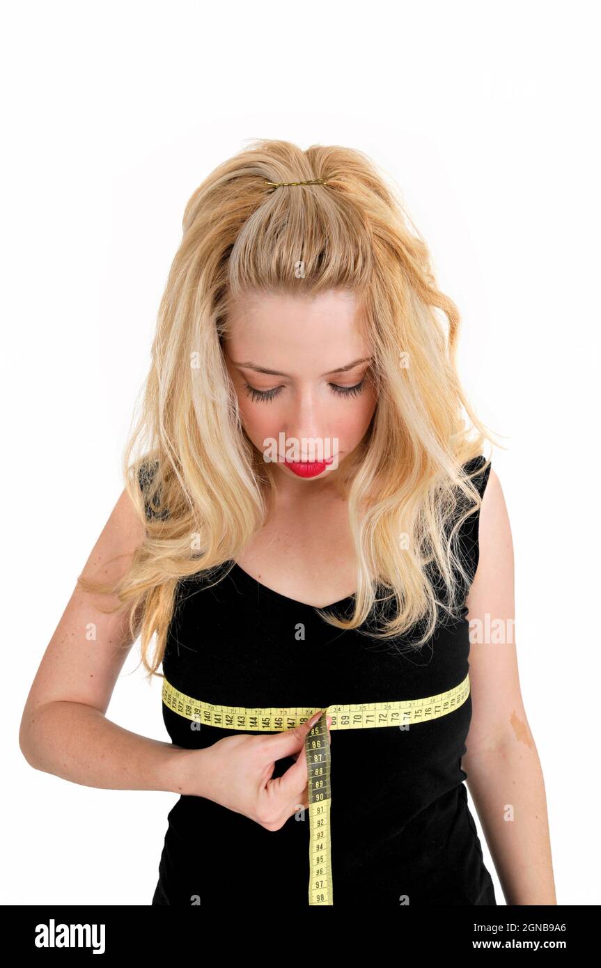 Body image - young woman measures her bosom Stock Photo