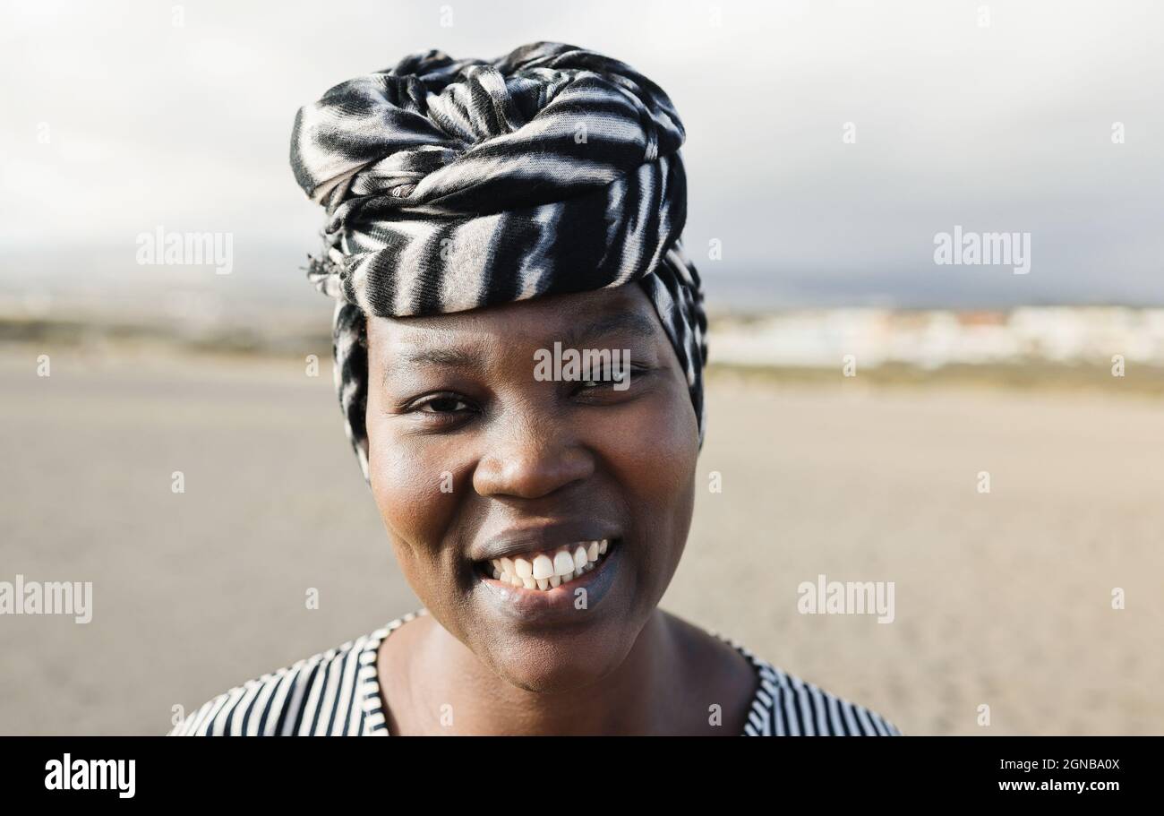 Portrait of happy african woman looking at camera outdoor - Focus on face Stock Photo