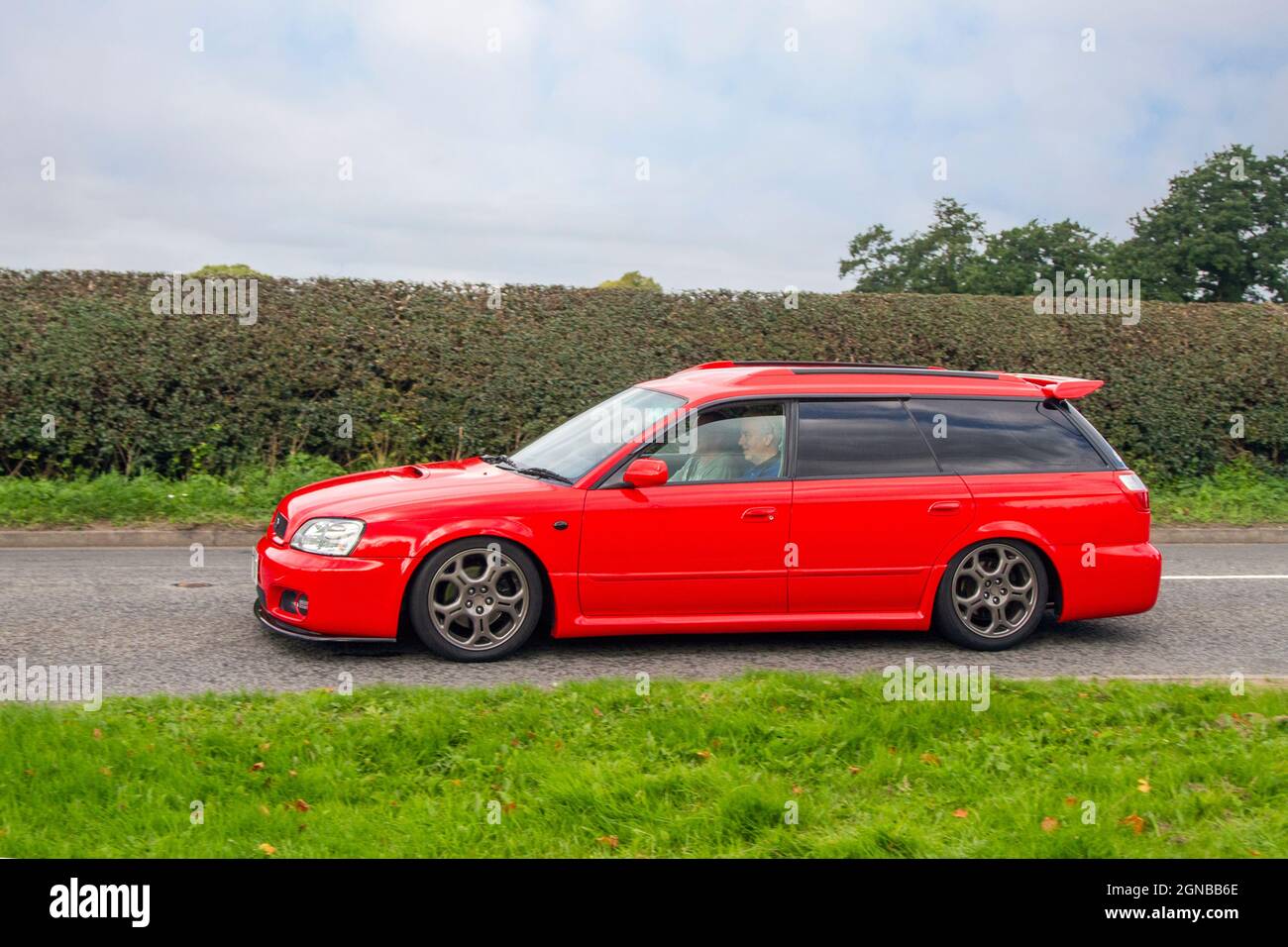 2002 red Subaru Legacy 1990cc 4dr estate en-route to Capesthorne Hall classic August car show, Cheshire, UK Stock Photo