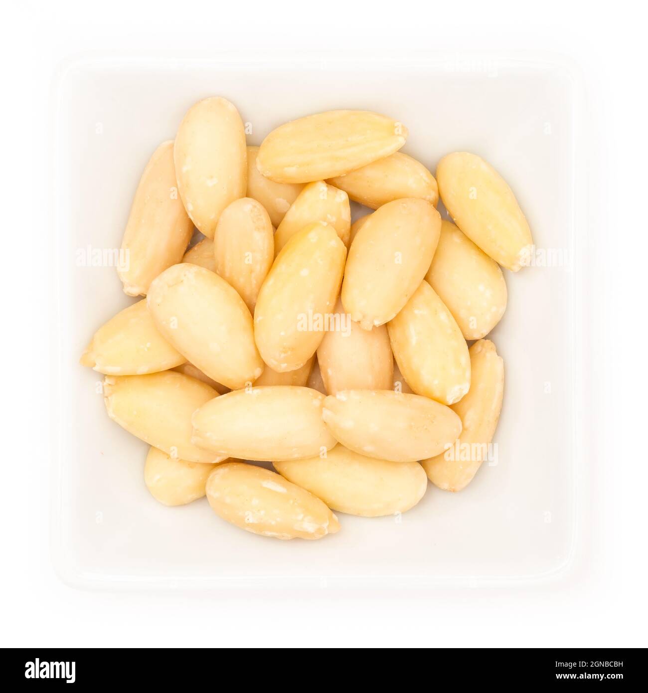 Closeup of peeled almonds in a white square bowl isolated on a white background Stock Photo