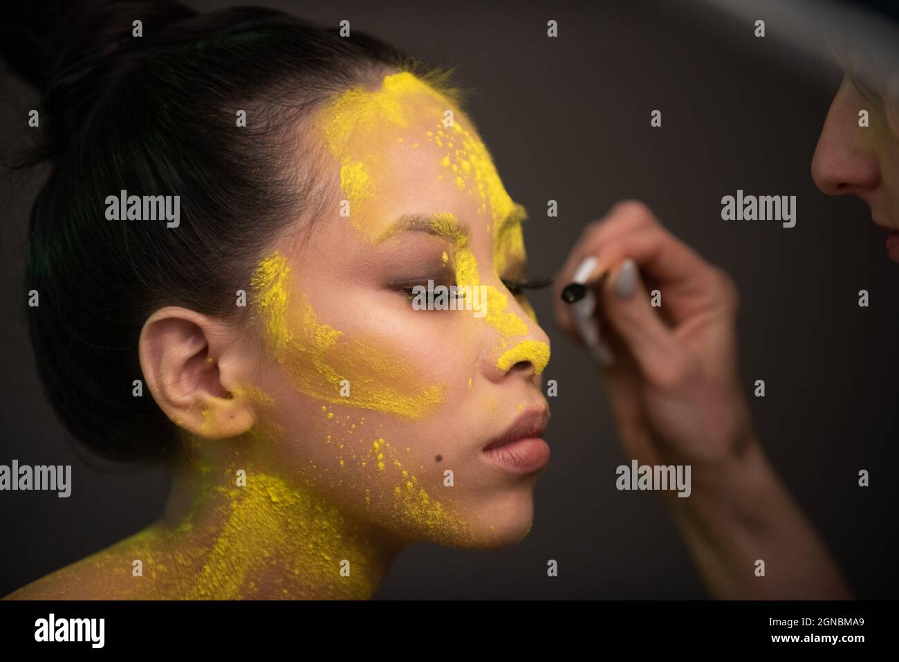 Portrait of asian woman with yellow powder paint on her face Stock Photo