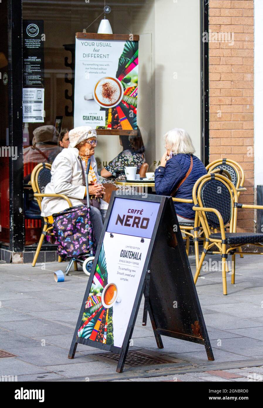Dundee, Tayside, Scotland, UK. 24th Sep, 2021. UK Weather: Warm sunshine with fresh westerly winds across North East Scotland, temperatures reaching 19°C. Local residents spending some time out enjoying the warm sunny weather outside the Italian Caffè Nero café having refreshments in Dundee city centre. Credit: Dundee Photographics/Alamy Live News Stock Photo