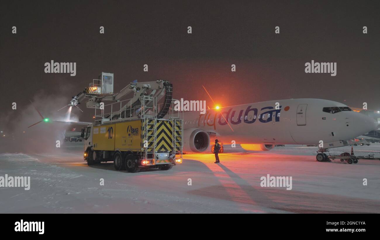 Deicing airplane Flydubai Boeing 7378 MAX at winter night Stock Photo