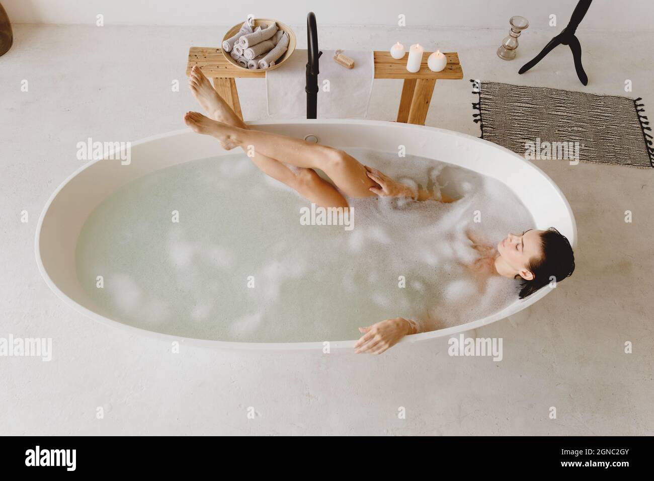 Beautiful woman relaxing in bathtub with foam. Stock Photo