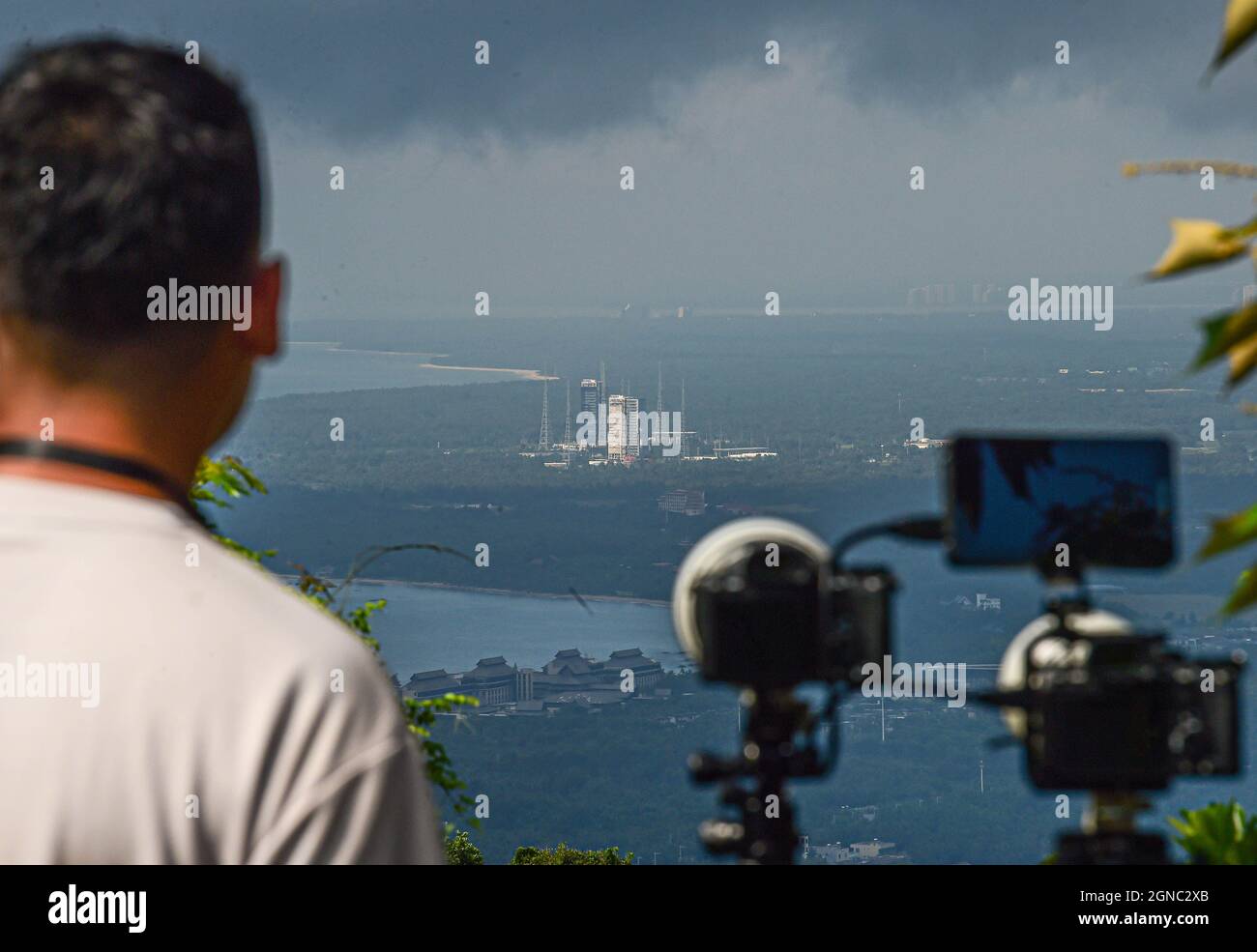 (210924) -- WENCHANG, Sept. 24, 2021 (Xinhua) -- Aerospace photography enthusiast Guan Tianyu waits to capture the moment of blast-off of the Long March-7 Y4 rocket, carrying Tianzhou-3, on top of a hill in Wenchang City, south China's Hainan Province, Sept. 20, 2021. The Long March-7 Y4 rocket, carrying Tianzhou-3, blasted off from the Wenchang Spacecraft Launch Site on Sept. 20, 2021, right in front of numerous cameras erected by photography enthusiasts with special interest in astronautics. Enchanted by the sophisticated launching technologies and the tremendous challenges of shooting the l Stock Photo