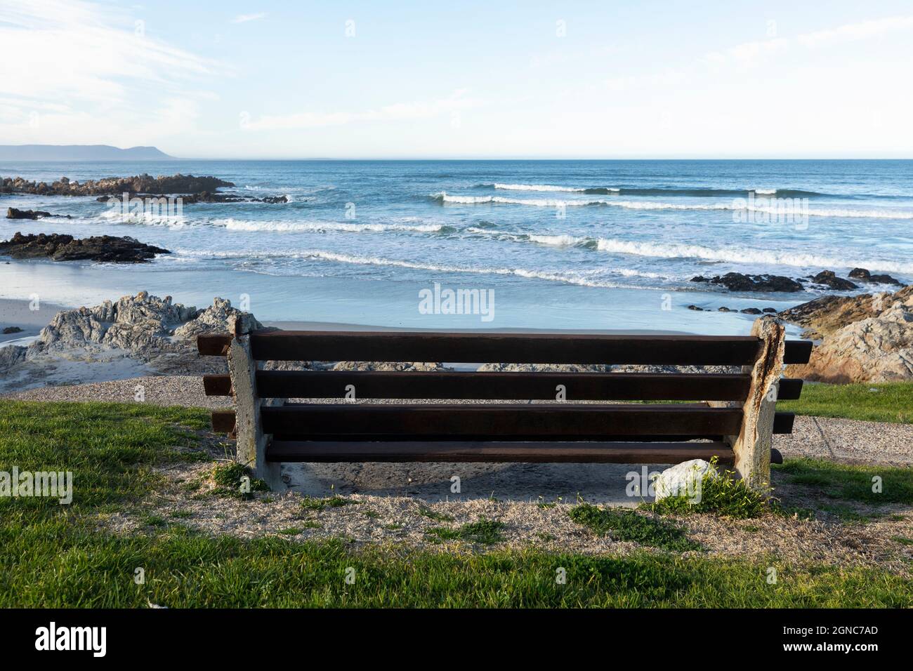 Bench overlooking a beach, jagged rocks and rockpools on the Atlantic coast. Stock Photo