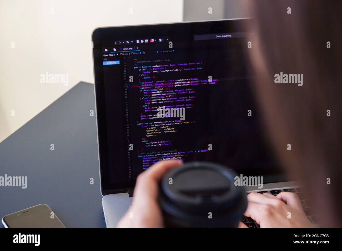 A programmer coding on a laptop in the workplace Stock Photo