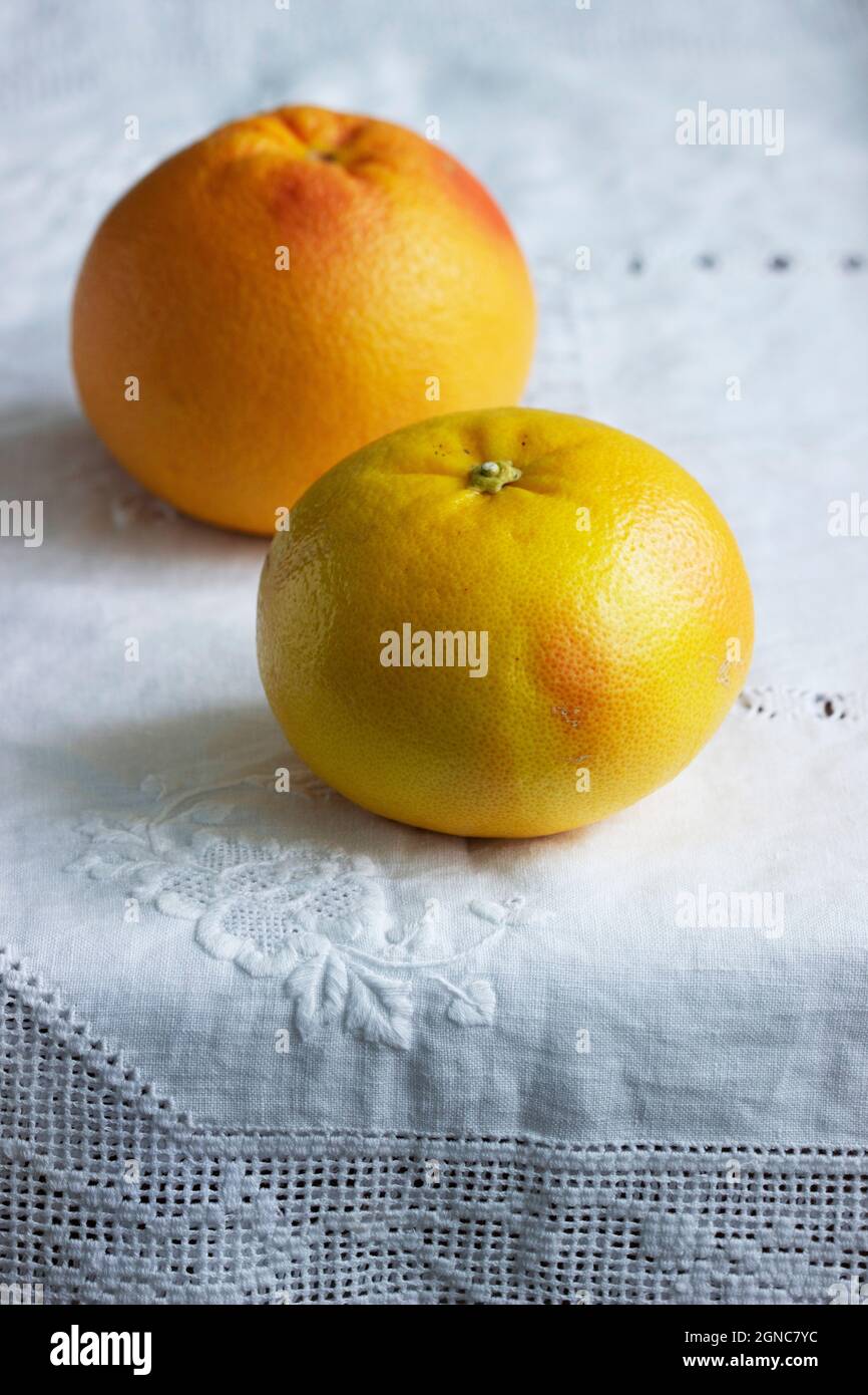 Ripe grapefruits on a white screwed tablecloth. Stock Photo