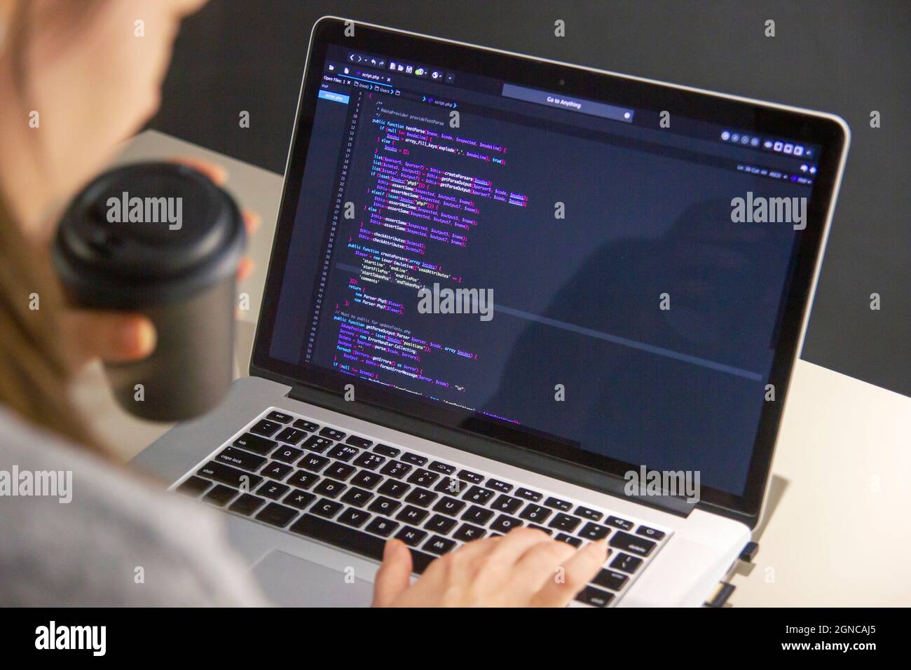 A programmer coding on a laptop in the workplace Stock Photo