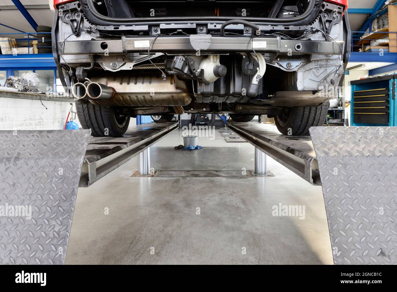 Car under repair on a service ramp or lift in an auto repair