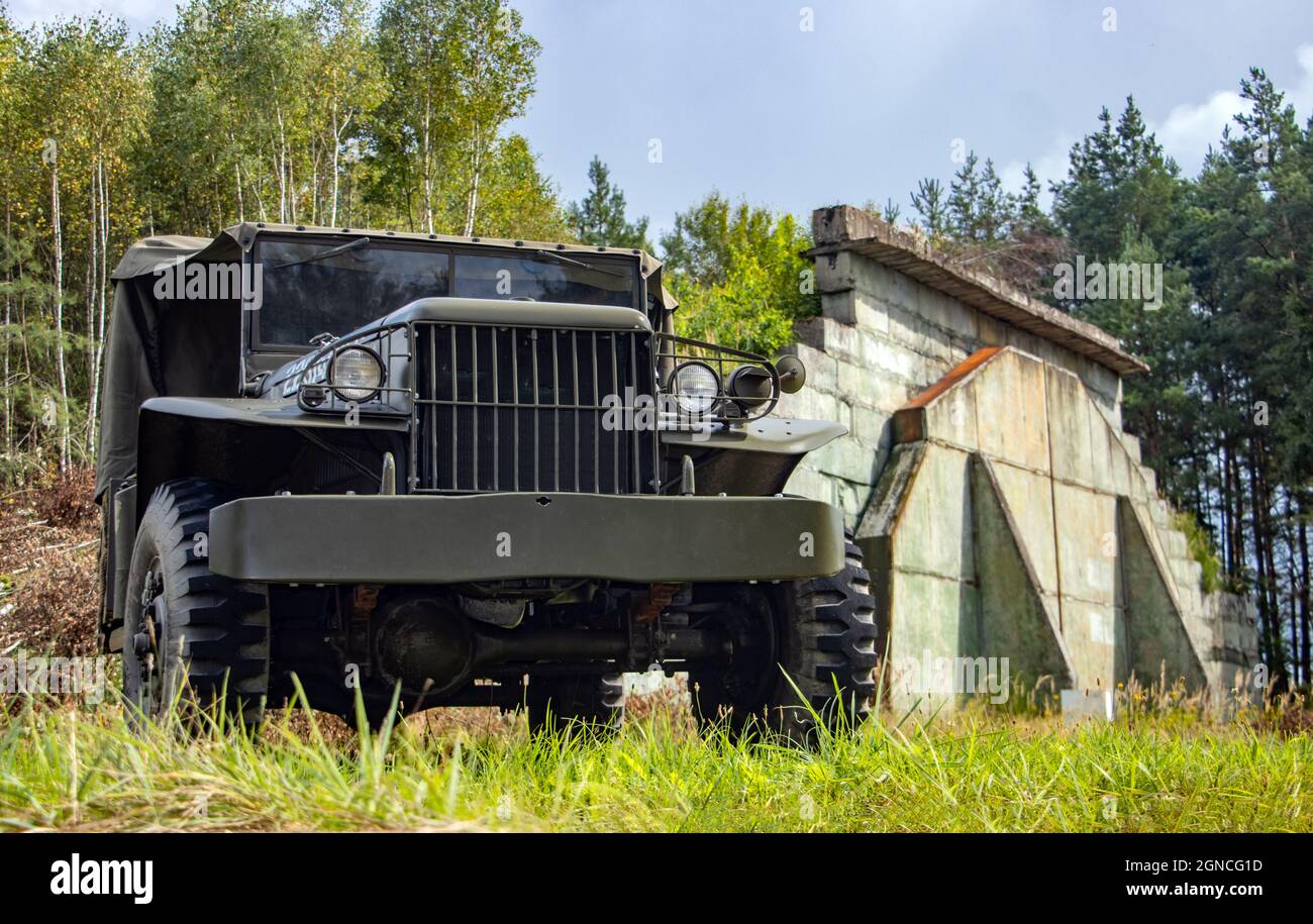 A historic US-made army off-road car stands in front of Hangars at a former military airport. Stock Photo