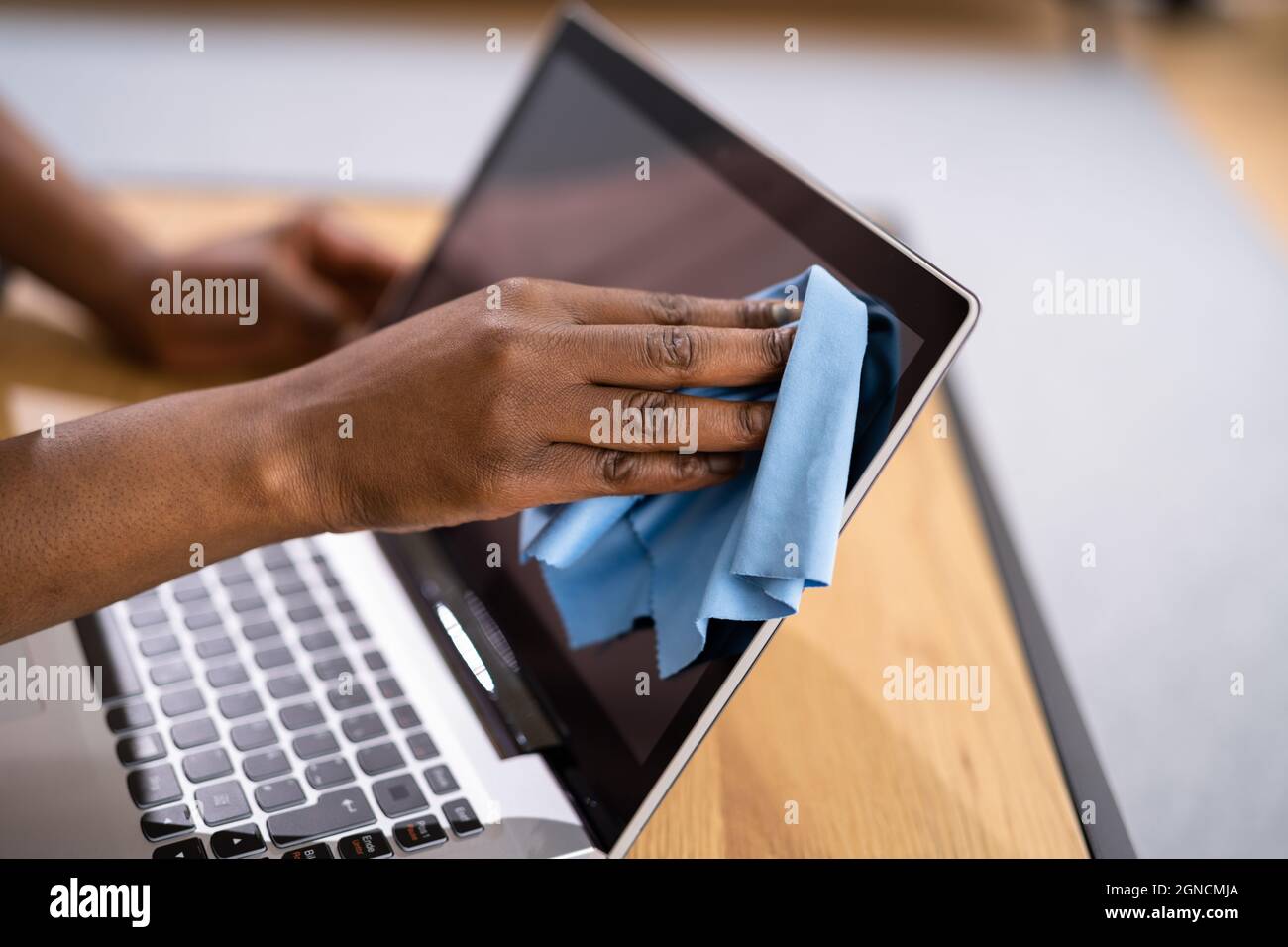 Woman Hand Cleaning Laptop Screen With Laptop At Home Stock Photo