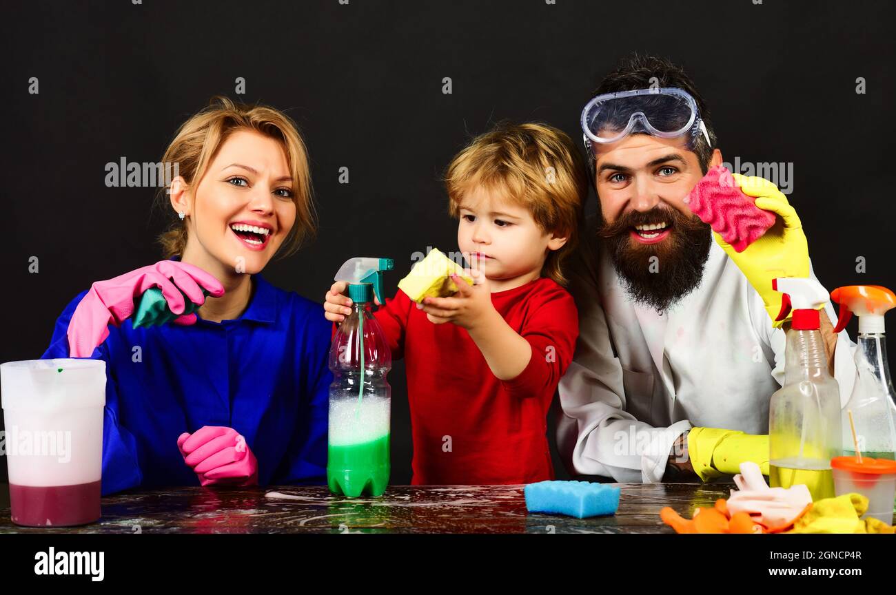 Home Cleaning. Happy mother, father and little son with cleaning products. Cute little helper Stock Photo