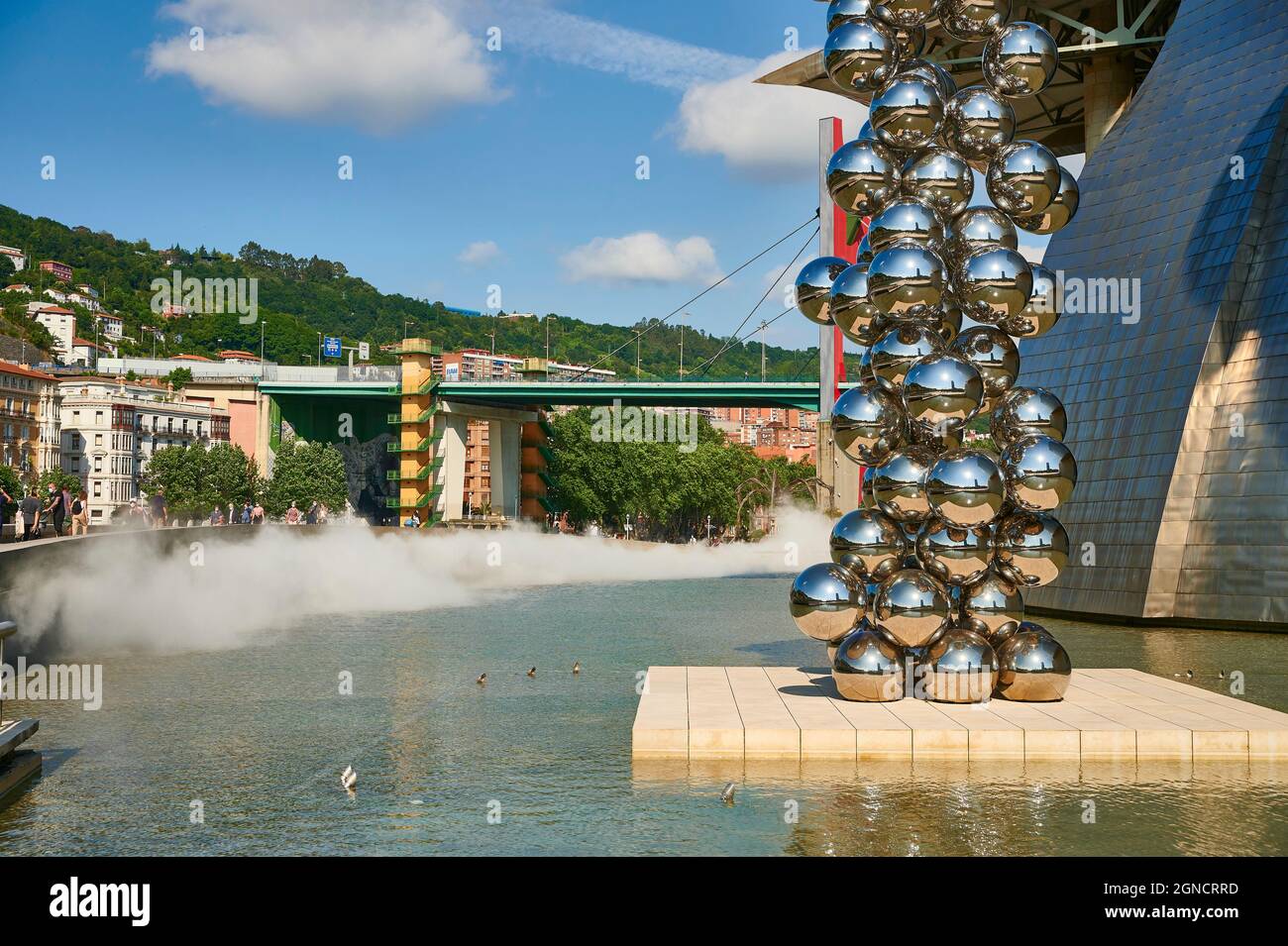 Guggenheim Museum and the sculpture “Tall tree and the eye” by Anish Kapoor with “La Salve” bridge on the background, Bilbao, Vizcaya, Basque Country, Stock Photo