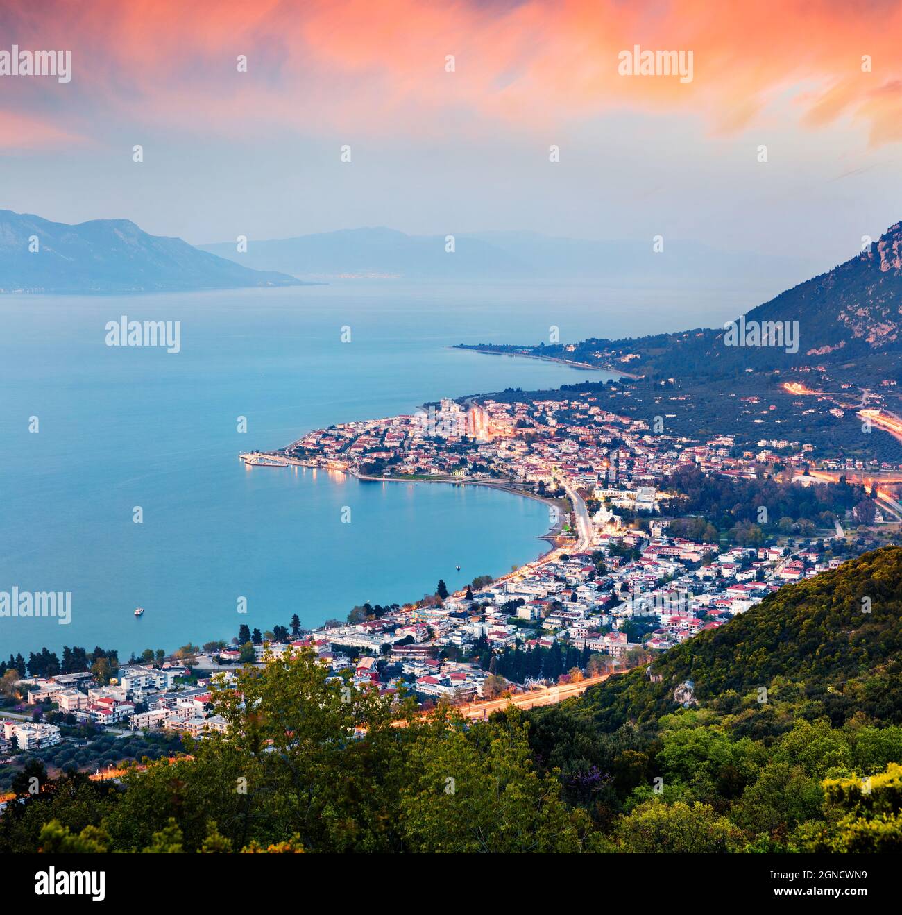 View from the bird's-eye of Kamena Vourla town in the evening mist. Colorful spring cityscape in Greece, Europe. Beautiful sunset on Aegean Sea. Artis Stock Photo