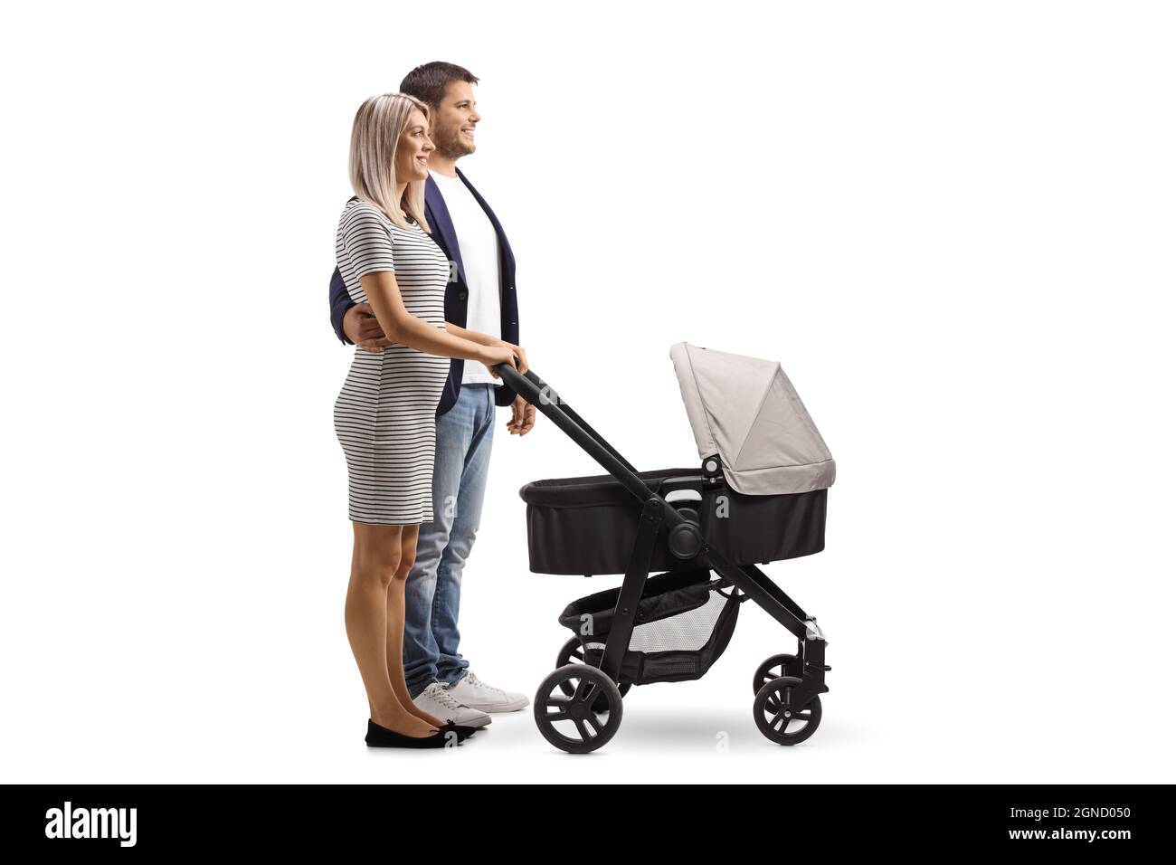 Full length profile shot of a young couple standing with a baby stroller isolated on white background Stock Photo