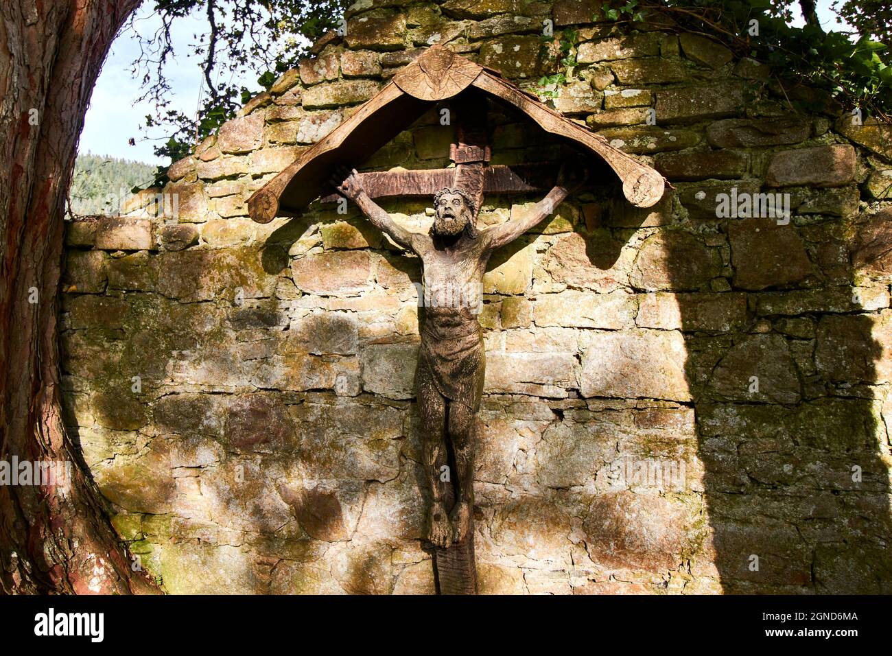 PLUSCARDEN ABBEY CATHOLIC BENEDICTINE MONASTERY MORAY SCOTLAND THE CEMETERY AND WOODEN CRUCIFIX ON A WALL Stock Photo
