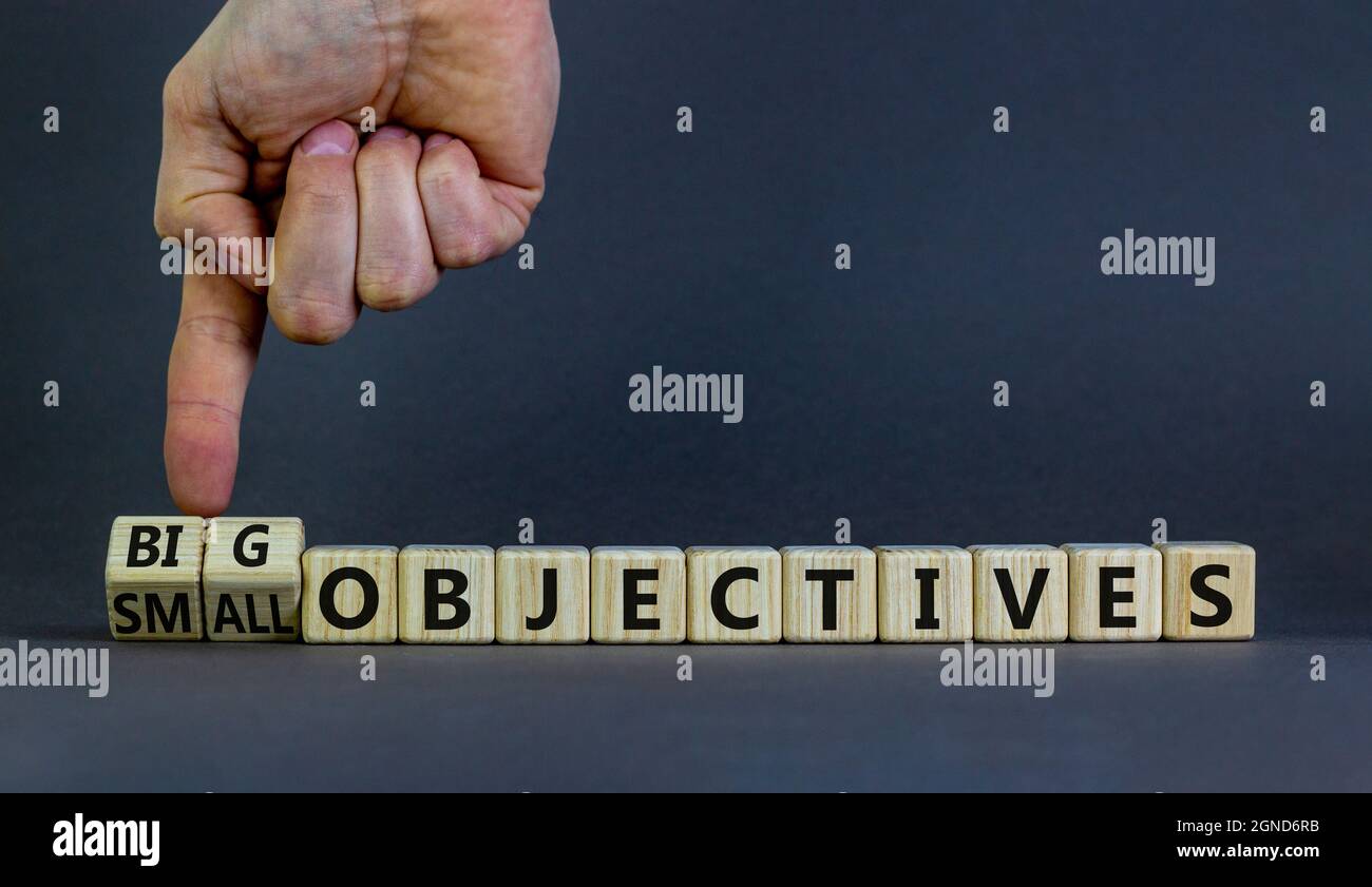 Big or small objectives symbol. Businessman turns wooden cubes, changes ...