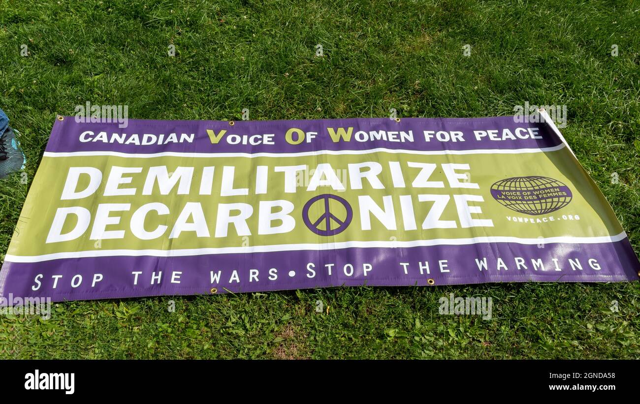A sign by the Canadian Voice of Women for Peace reading 'Demilitarize, Decarbonize' during the Global Climate March organized by Fridays For Future in Stock Photo