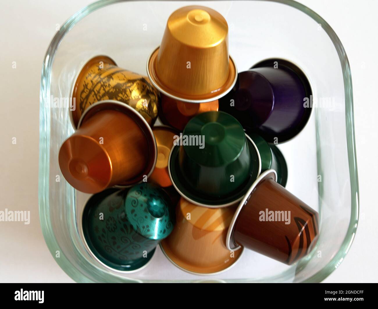 A glass bowl with colorful coffee capsules of different strengths. Stock Photo
