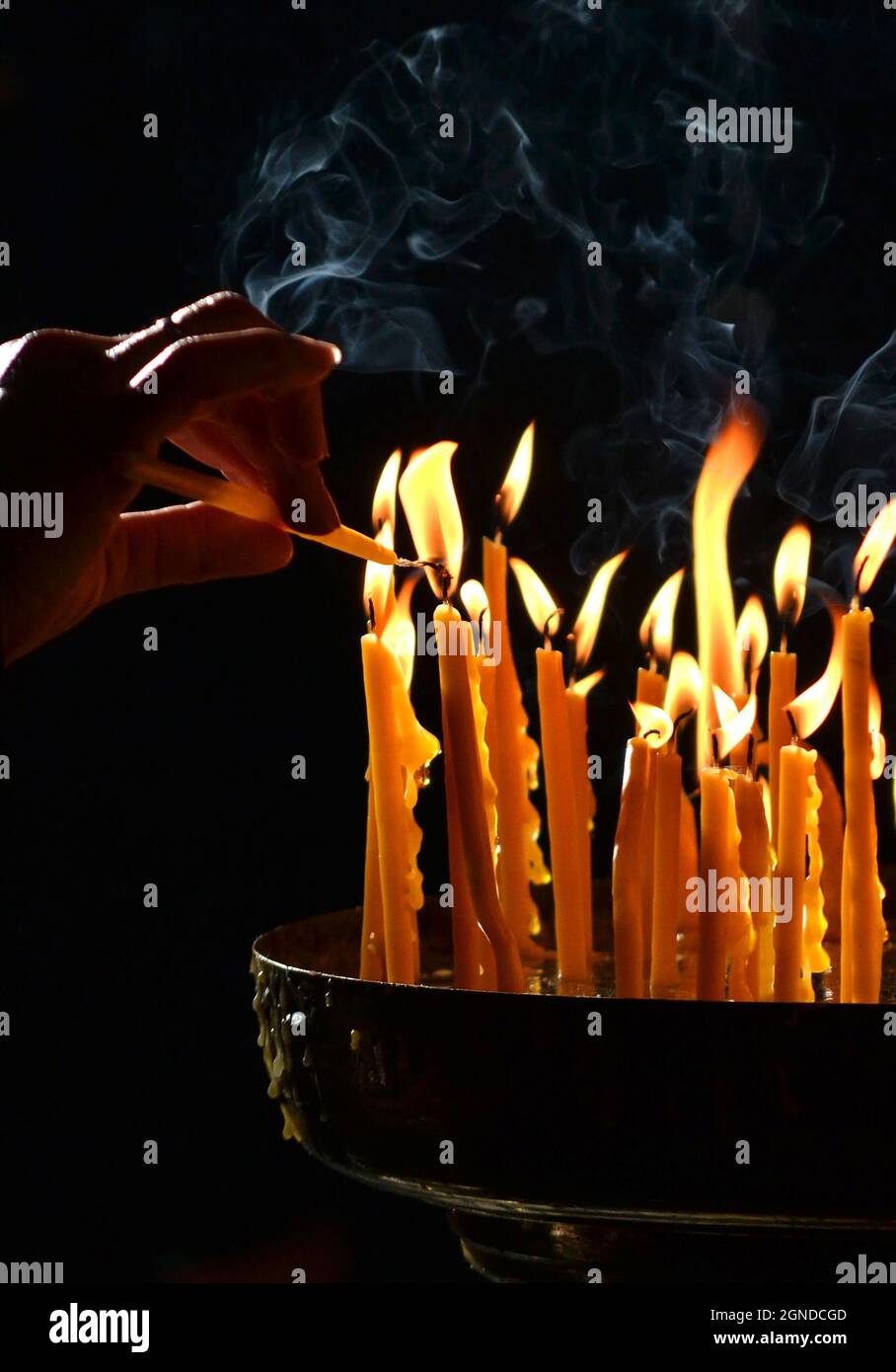 human hand lights a candle in the church Stock Photo - Alamy