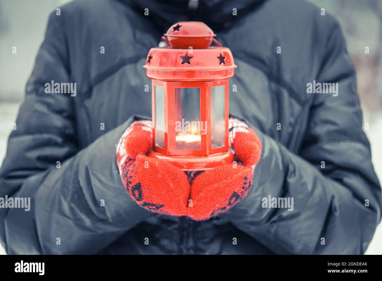 Man holding a red candle lantern with a candle close up Stock Photo