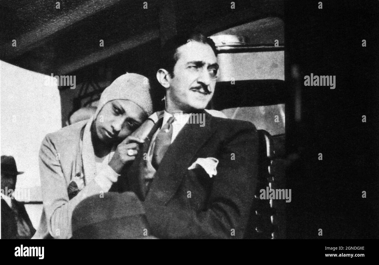 1929 ca. , FRANCE  : The celebrated american black singer and dancer JOSEPHINE BAKER ( 1906 - 1975 ) with his italian  housband and manager , the sycilian   ( fake Count ) Giuseppe ' Pepito ' ABATINO ( 1898 - 1936 ). -  musical - ballerina - cantante - di colore  - teatro - theatre - exotic - Parigi - Folies Bergeres - Moulin Rouge  - ritratto - portrait  - DANCE - DANZA  - JAZZ - hat - cappello - monocle - monocolo - tie - cravatta - innamorati - lovers - marito e moglie - sposi - married couple  ----  Archivio GBB Stock Photo