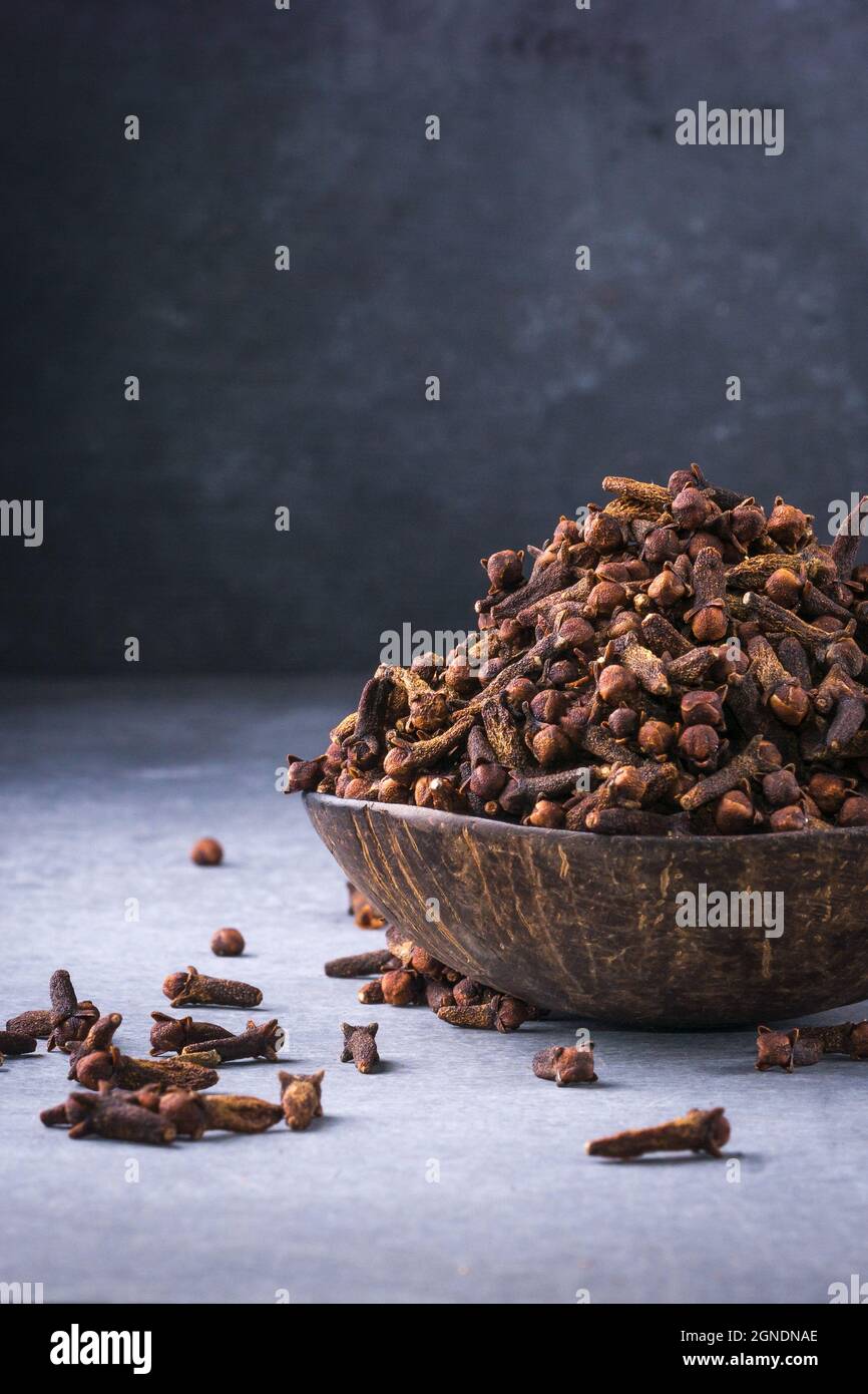 dried cloves in a cup made out of coconut shell, aromatic spice and
