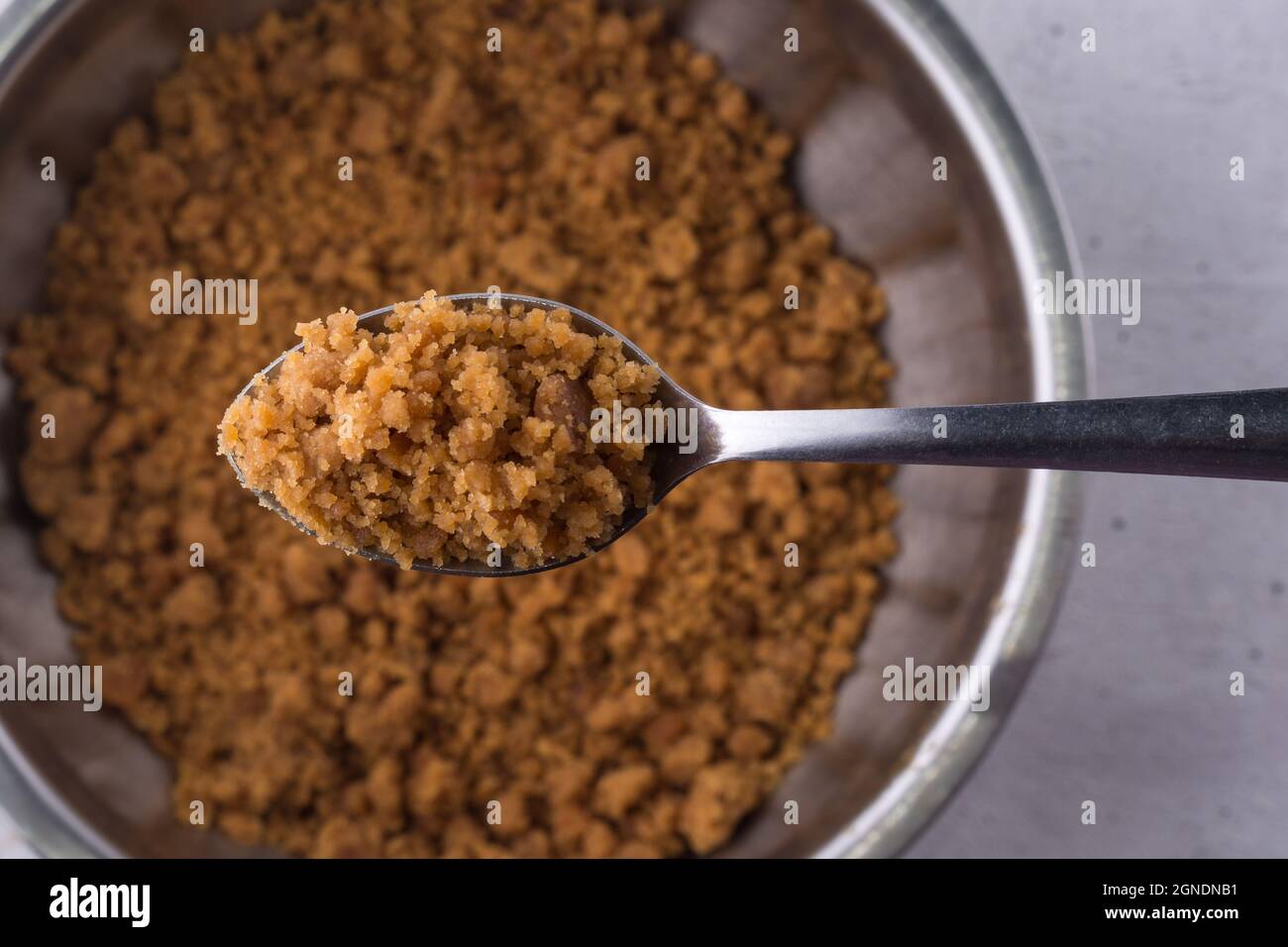 palm sugar on a spoon, golden brown color unrefined sugar product also