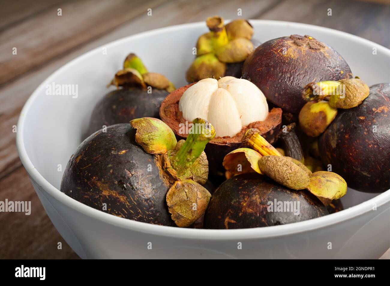 Closeup of edible flesh of an open mangosteen fruit & a bunch of other