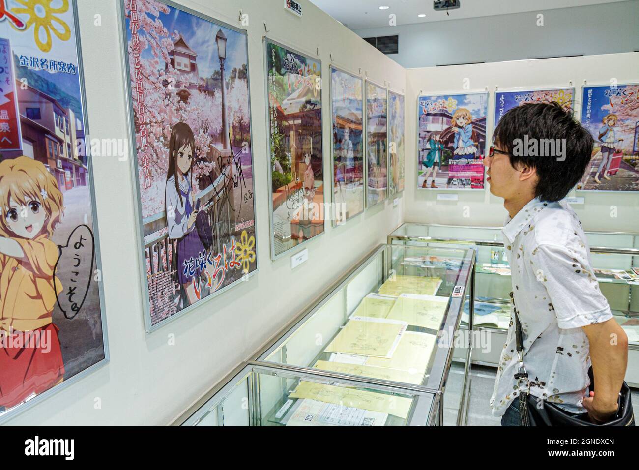 Tokyo Japan,Akihabara,Tokyo Anime Center exhibit exhibition collection,Asian boy looking movie posters movies cartoon characters Japanese Stock Photo