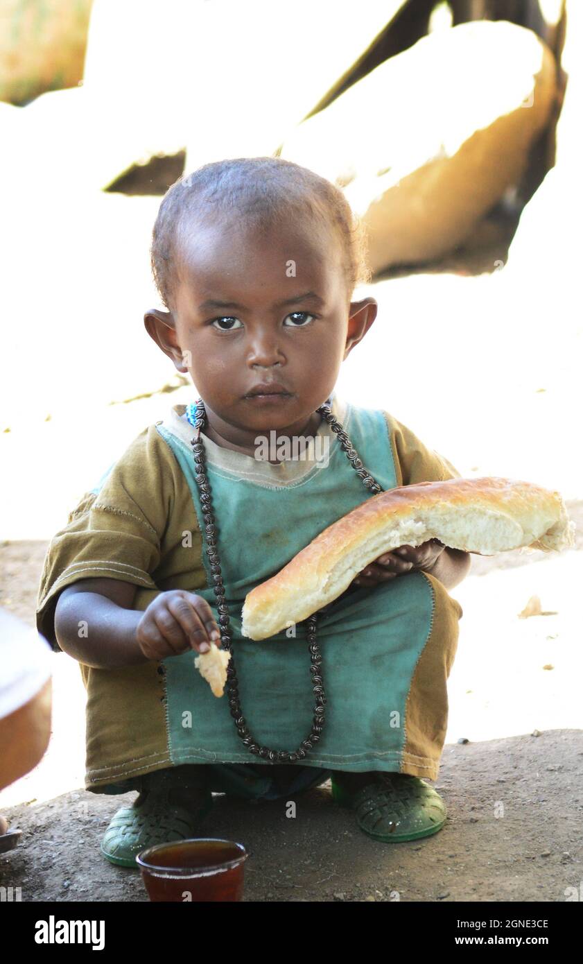 An Oromo boy eating bread at the market in Bati, Ethiopia. Stock Photo