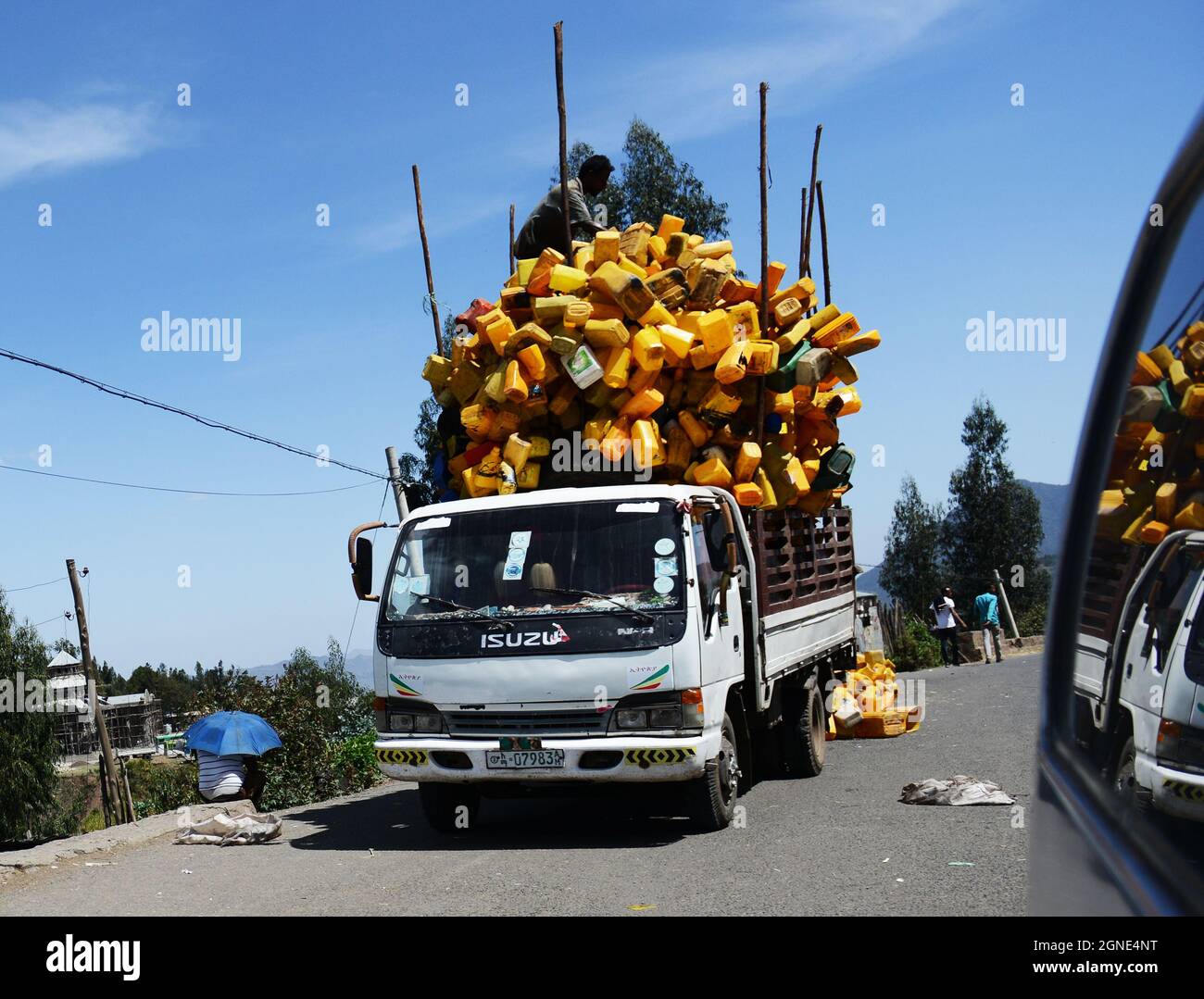 Ethiopian men loading a truck with empty yellow jerrycans. Stock Photo