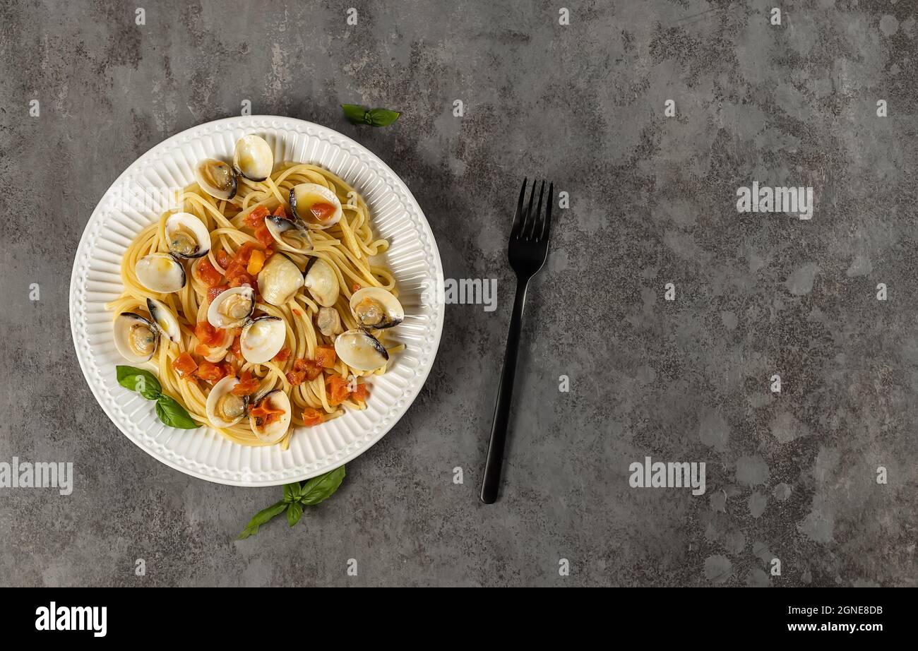 Spaghetti pasta with steamed clams. Fresh cooking Italian seafood recipe with tomatoes, garlic