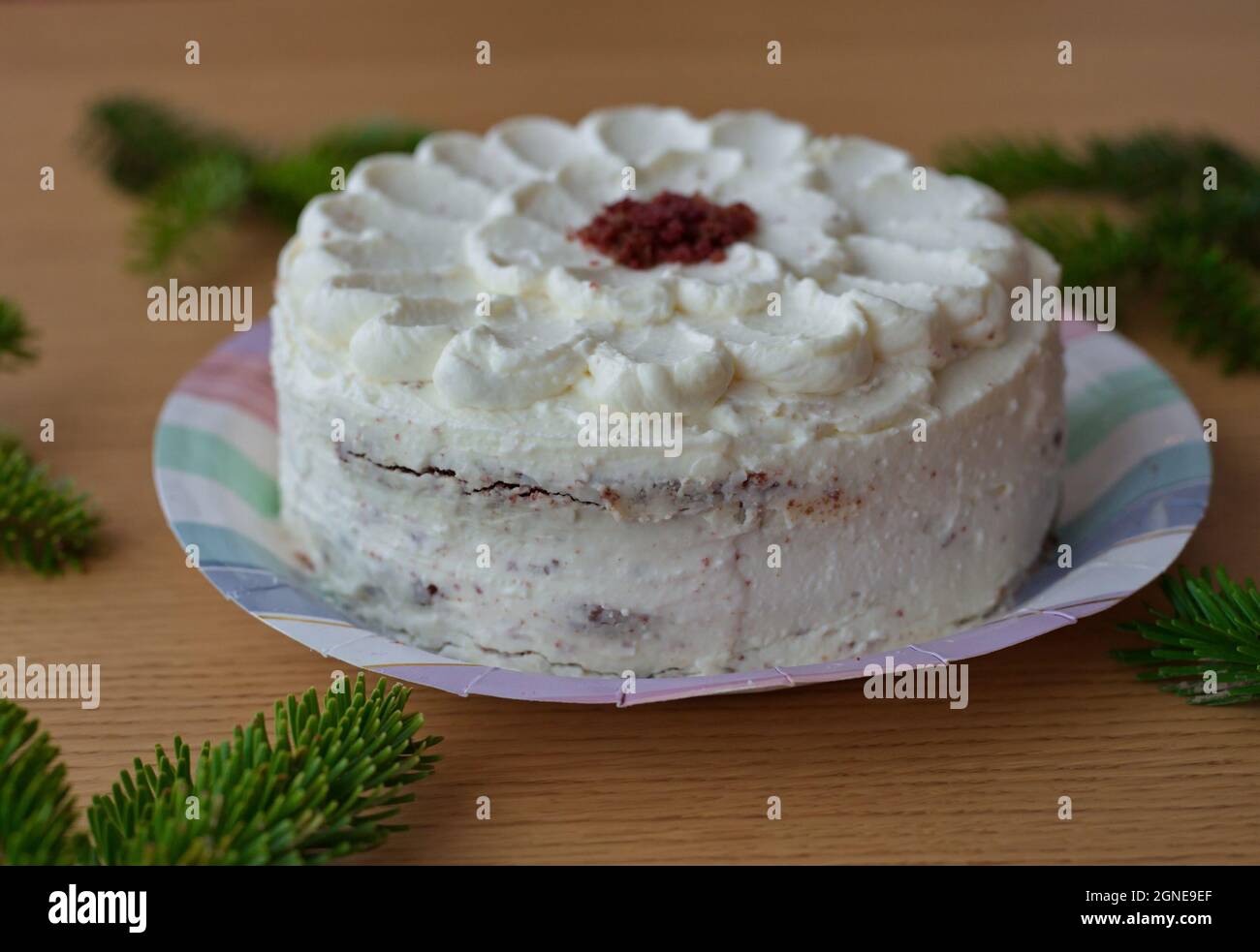 White cake on table with fir branches Stock Photo