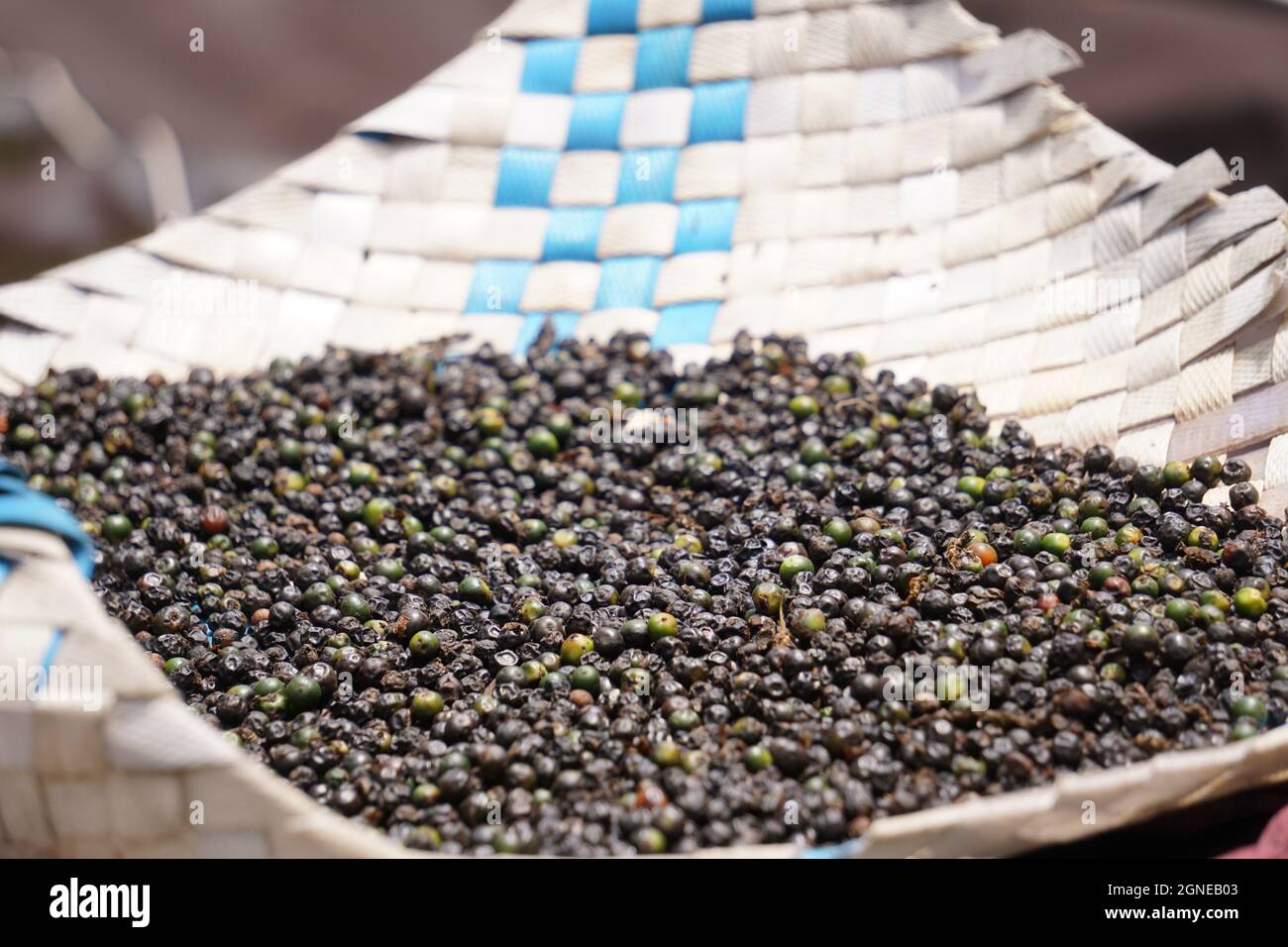 Sun dried black pepper on white surface Stock Photo