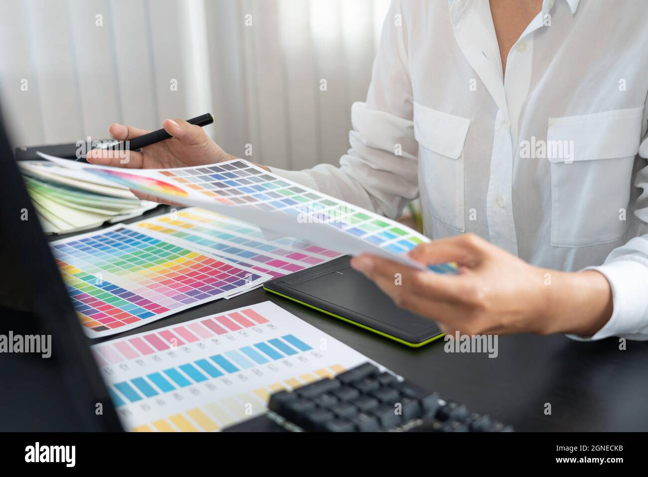 creative graphic designer choosing color scale for editing artwork while working in office Stock Photo