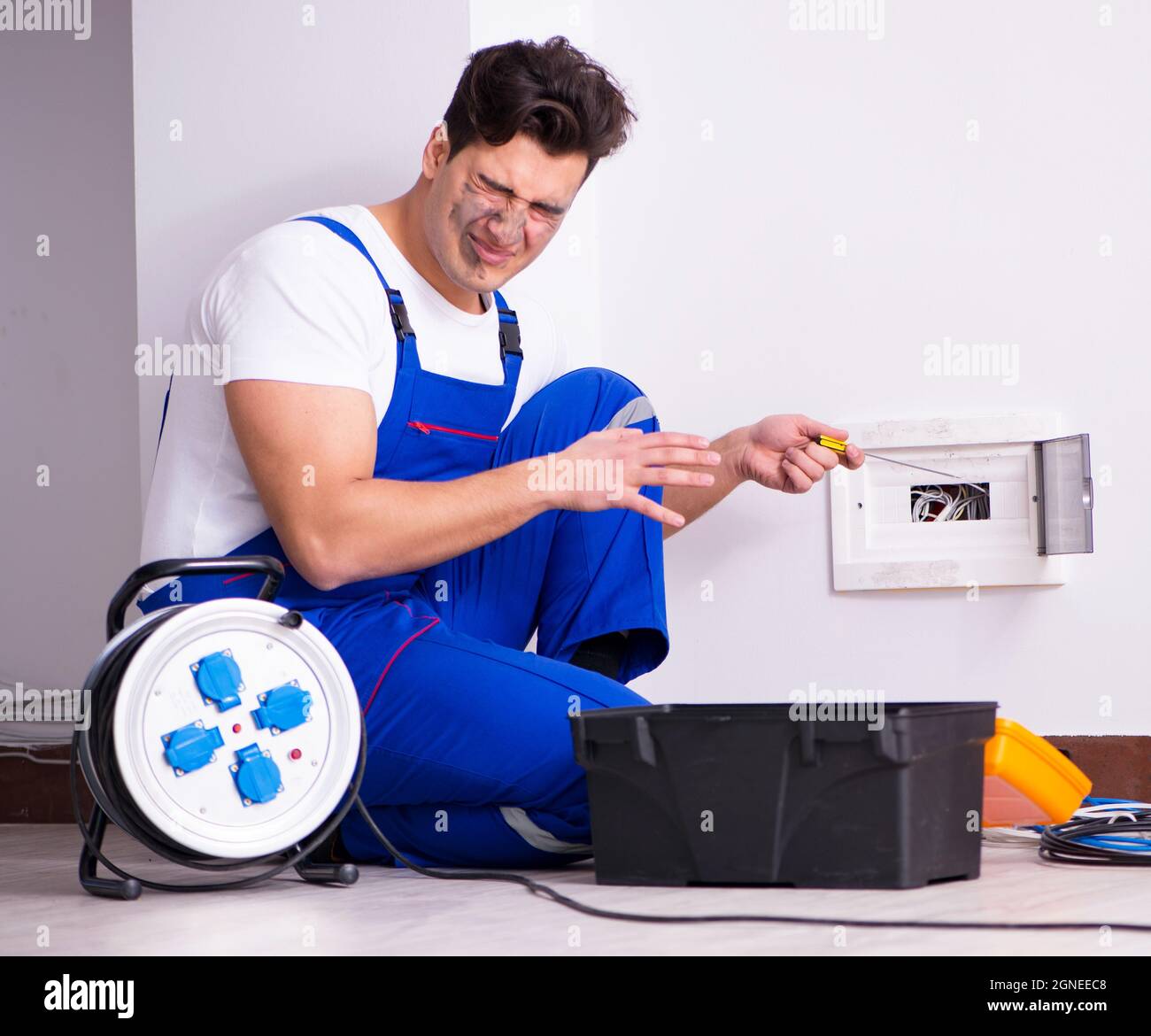 The funny man doing electrical repairs at home Stock Photo