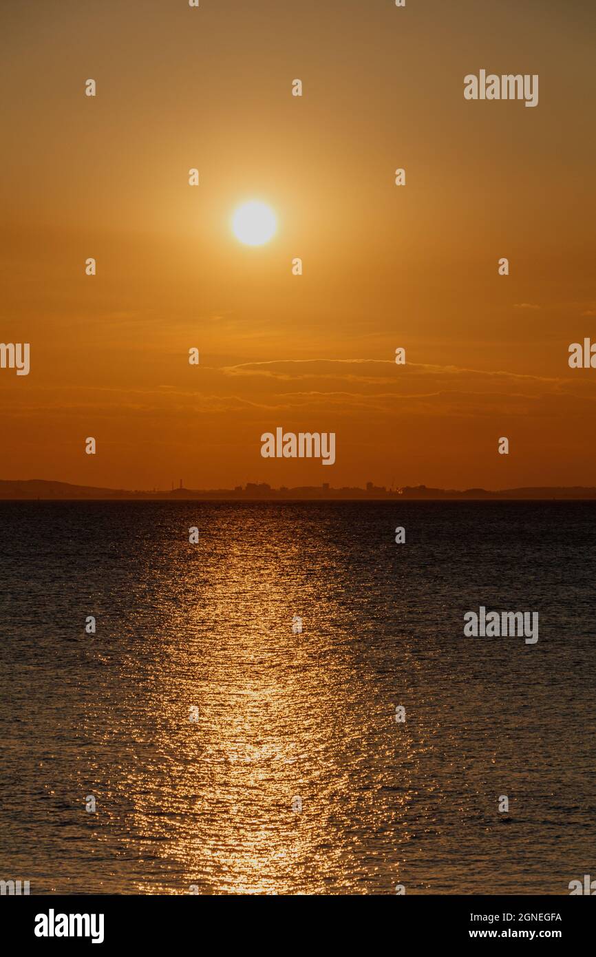 Streak of sunlight across the channel with a reddish glow on the