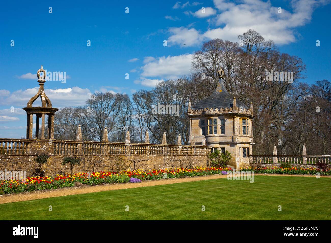 A colourful border of spring tulips and stone gazebo at Montacute House, an Elizabethan mansion with garden near Yeovil, Somerset, England, UK Stock Photo
