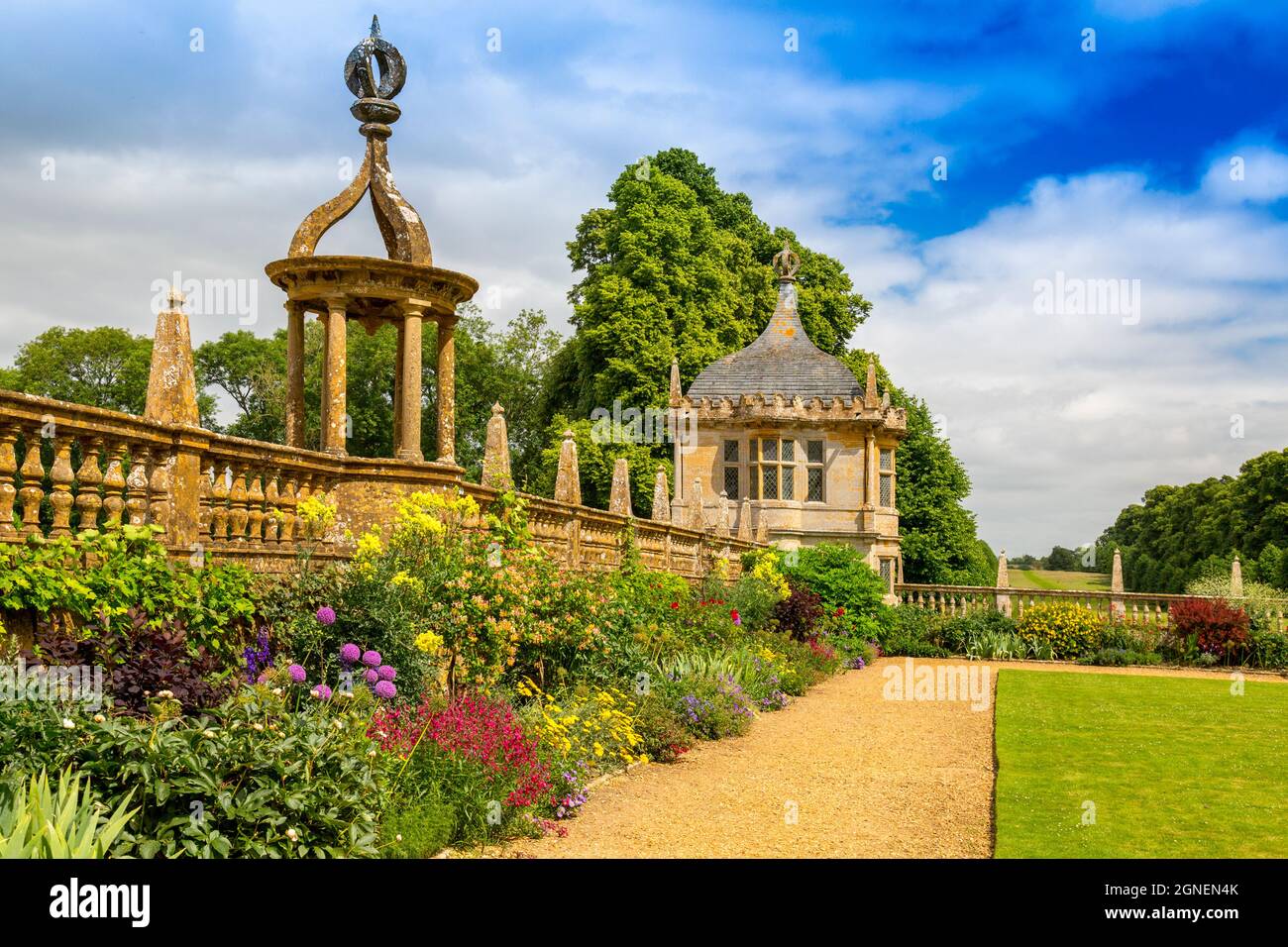 A colourful border and stone gazebo next to the east lawn at Montacute House, an Elizabethan mansion with garden near Yeovil, Somerset, England, UK Stock Photo