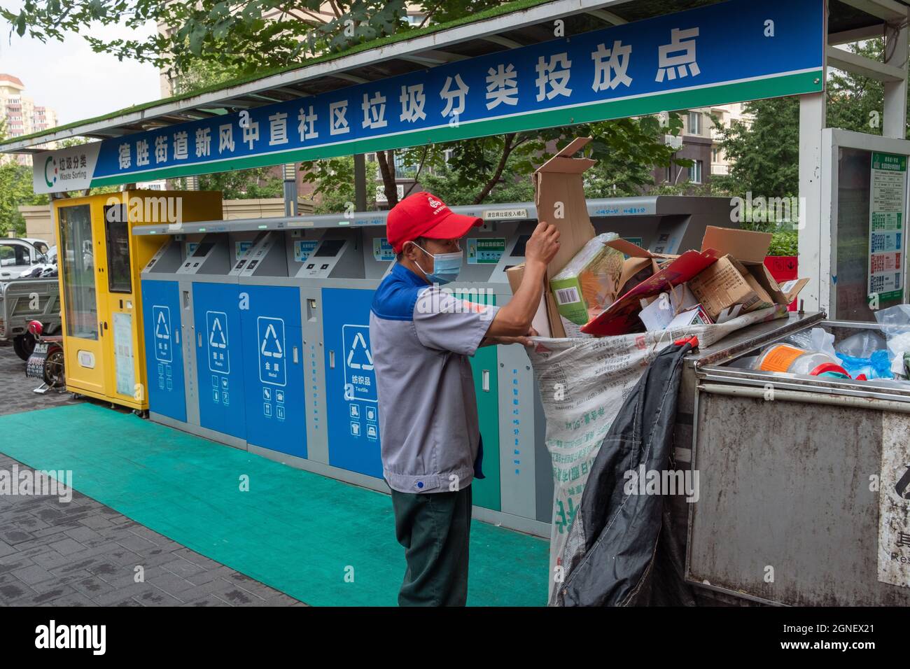Chinese collector collects rubbish from smart garbage-sorting dustbins in a residential compound in Beijing, China. 25-Sep-2021 Stock Photo