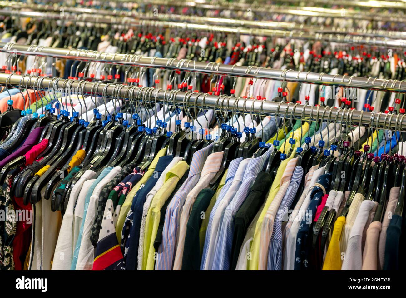 Shirts, blouses and vests on a clothes rack. Stock Photo