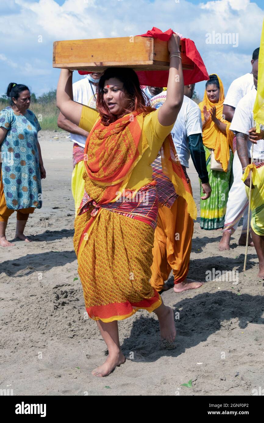 A devout Hinduu worshipper carries offerings to the deities at a Ganga and Kateri Amma Poosai service at jamaica Bay. In Queens, New York. Stock Photo