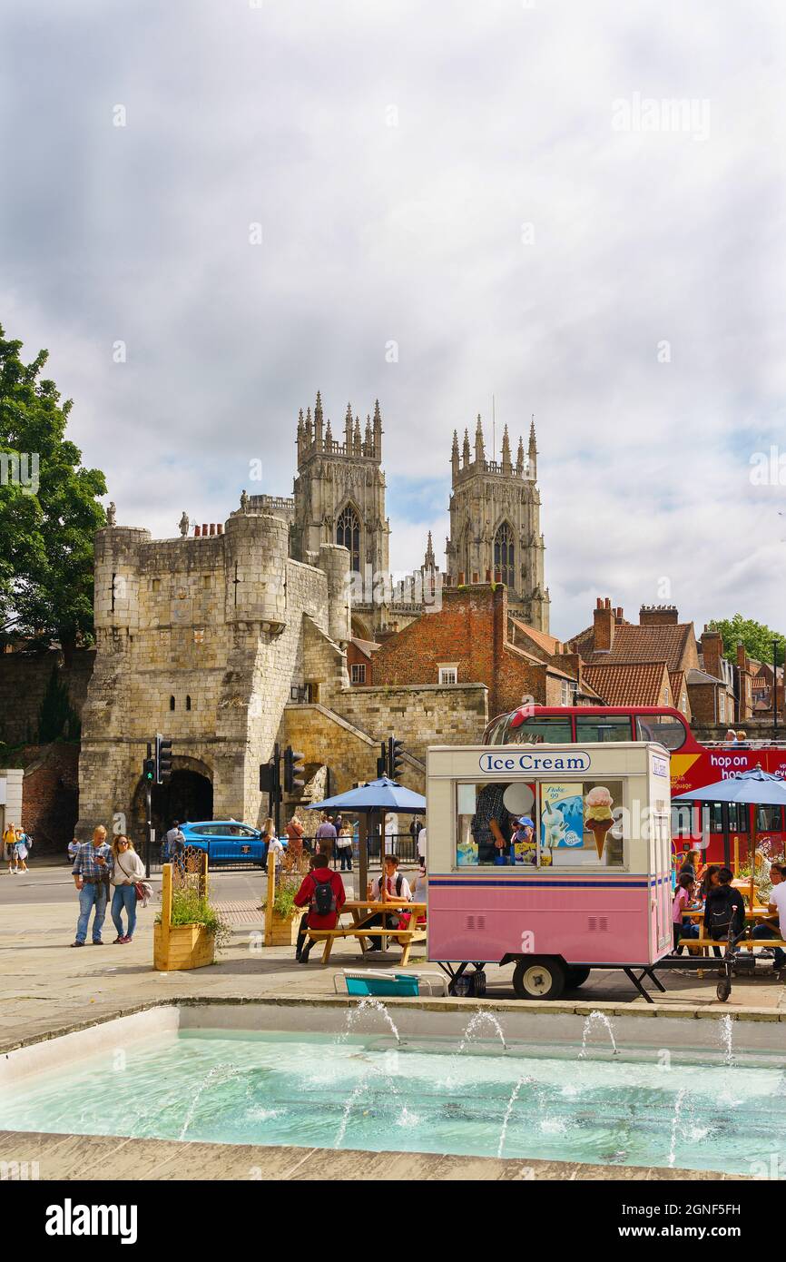 York Minster and the Monk Bar can be seen in the distance behind the ice cream van parked next to water fountain in Exhibition Square,York, UK. Stock Photo