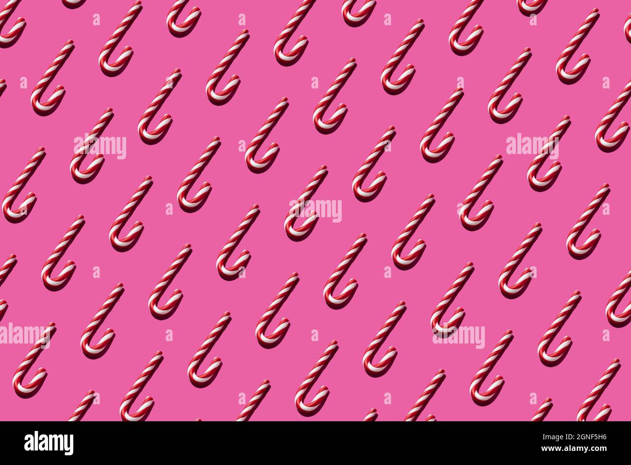 Christmas seamless candy cane pattern on pink background for festive