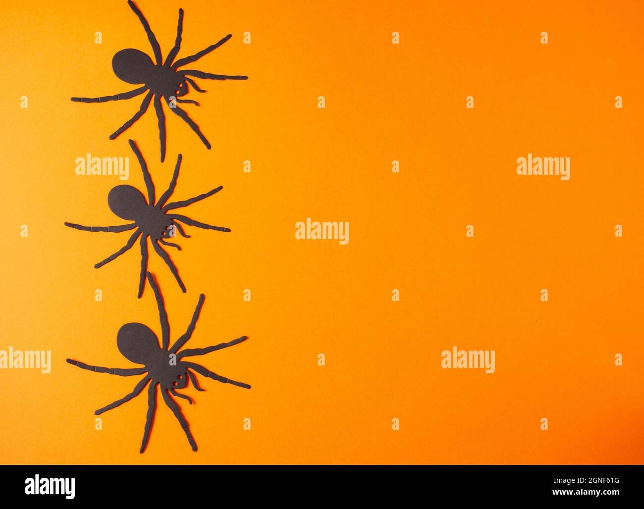 Vibrant orange background with metallic black widow spiders on the ...