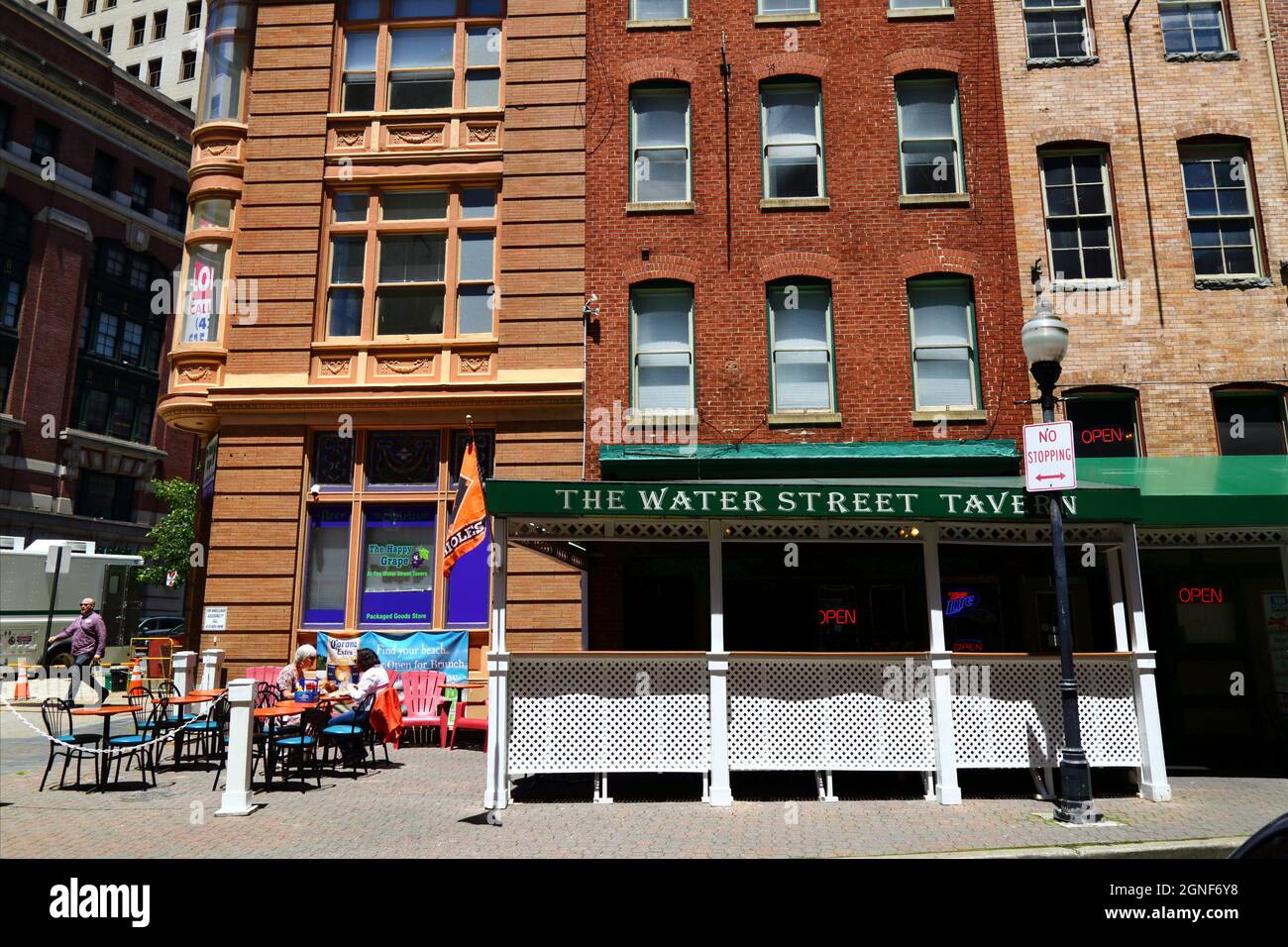 2 women sitting at a table on sidewalk outside The Water Street Tavern at 102 Water St, Baltimore, Maryland, USA Stock Photo