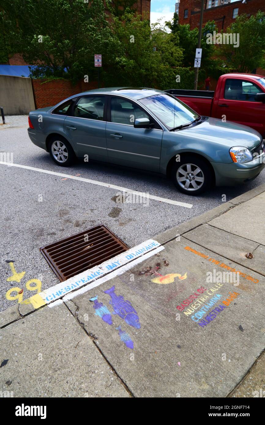 Writing in Spanish language on sidewalk next to a drain telling people not to drop litter that contaminates the Chesapeake Bay, Baltimore, USA Stock Photo